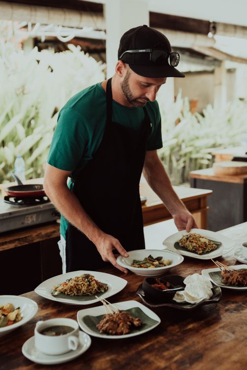 A chef preparing traditional Balinese dishes in an open kitchen