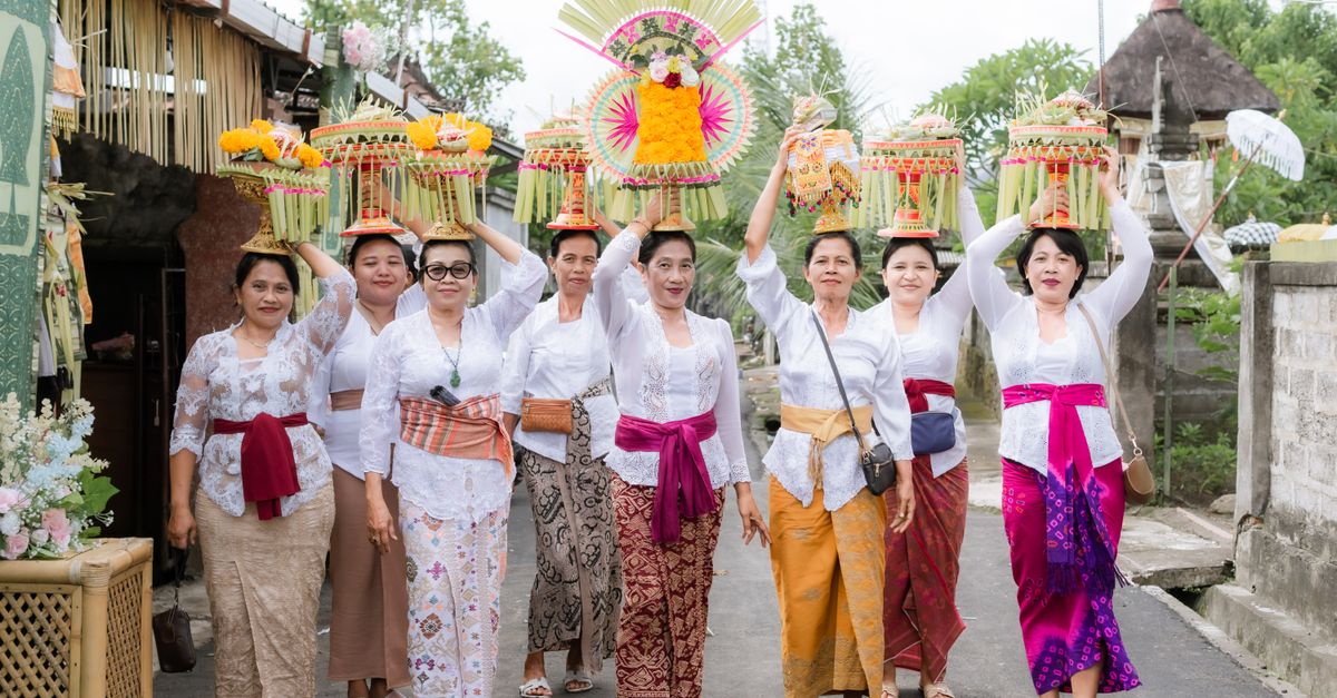 Balinese women in traditional dress carrying ceremonial offerings in a procession