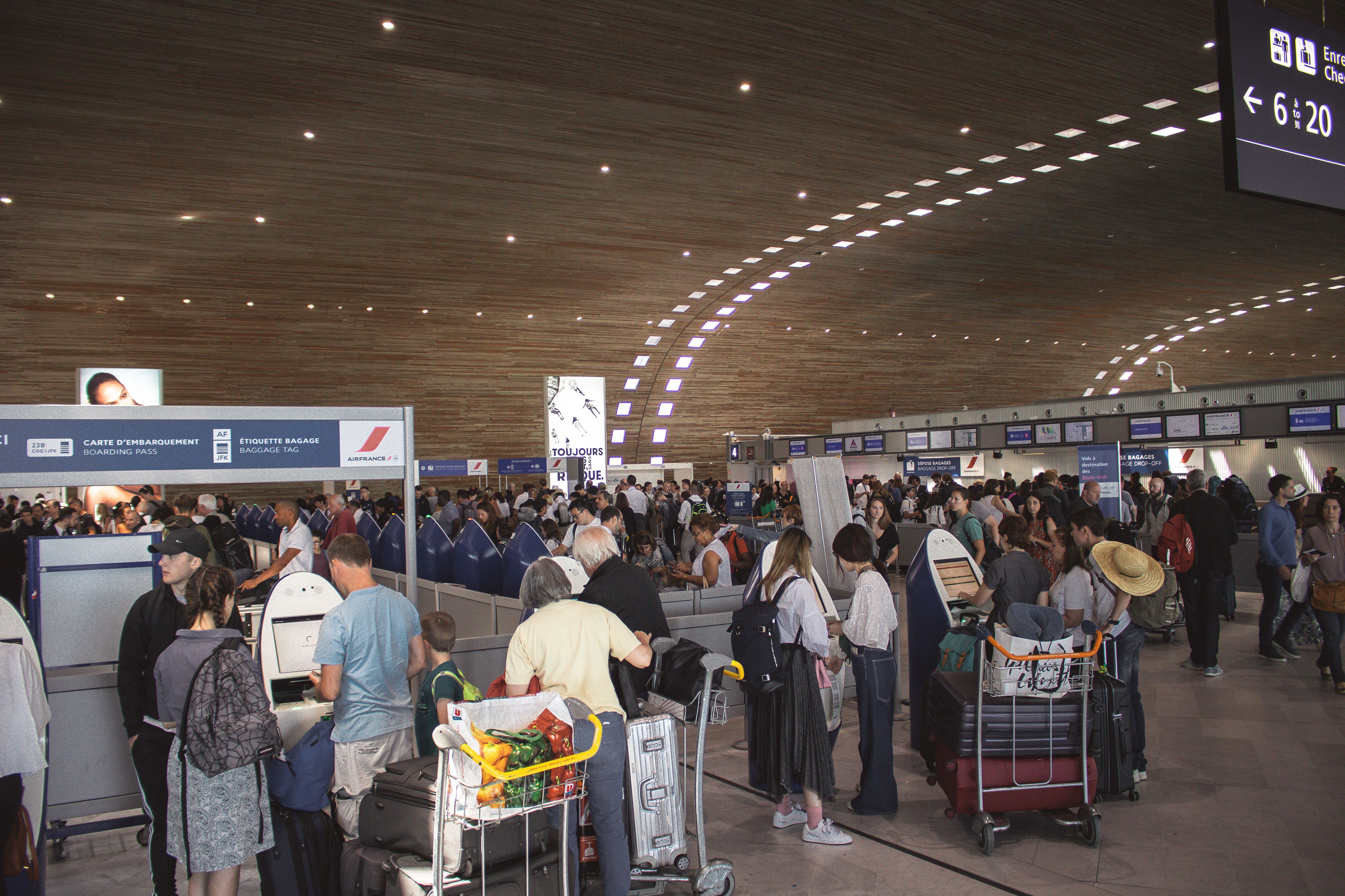 Crowded airport terminal with travellers queuing