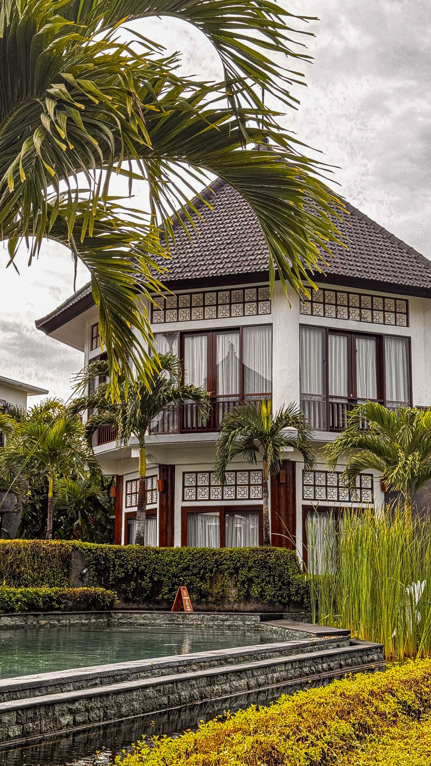 Luxurious Bali villa resort with palm trees and manicured tropical gardens