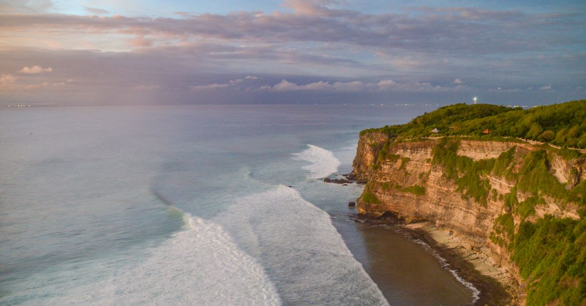 Dramatic cliffside view over the ocean at Uluwatu, Bali at sunset