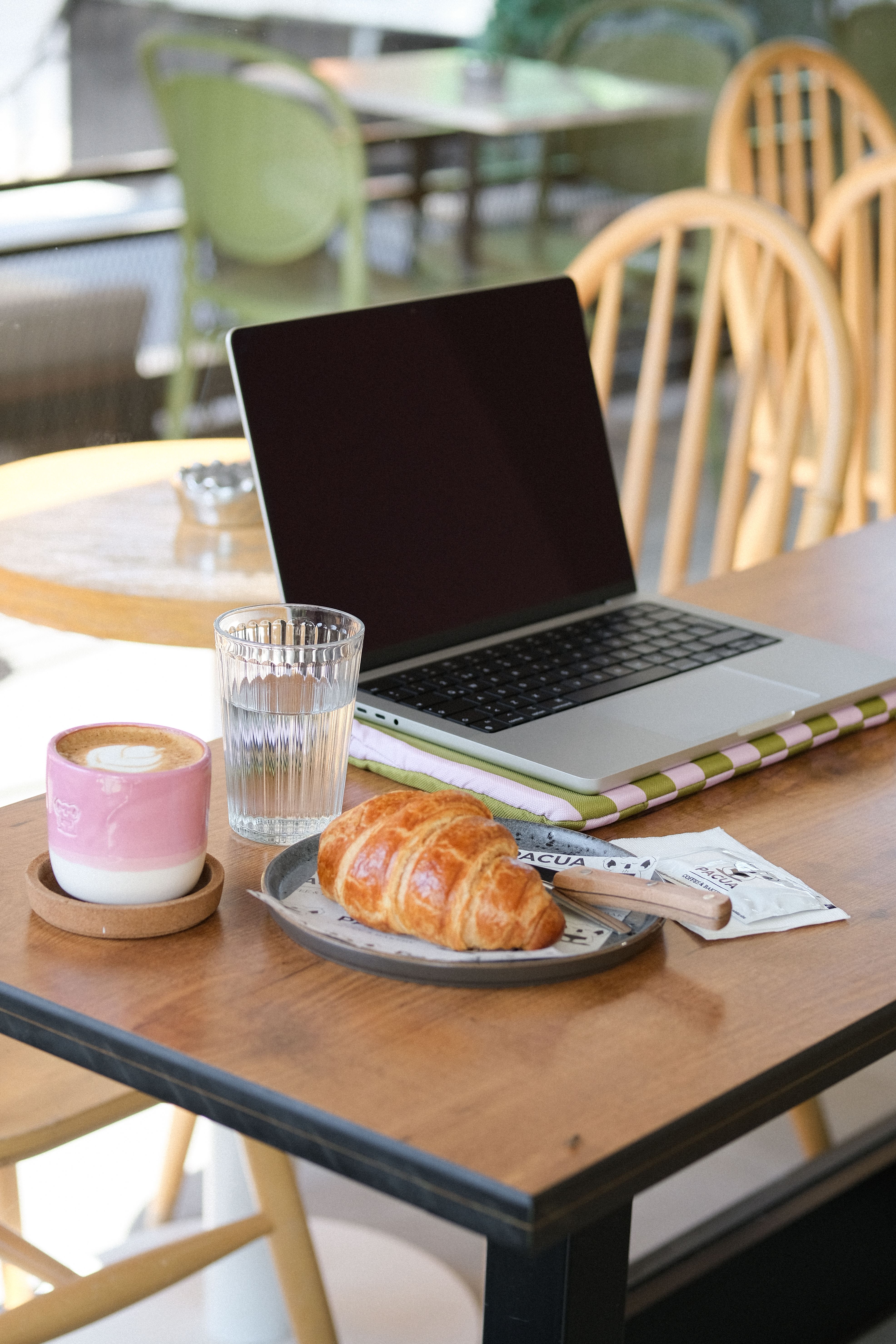 Cosy café workspace with laptop and coffee, the daily office for digital nomads in Bali