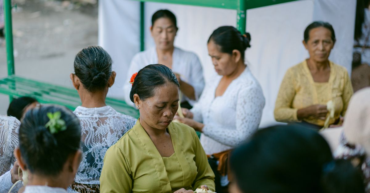 Women in traditional Balinese dress participate in a cultural ceremony.
