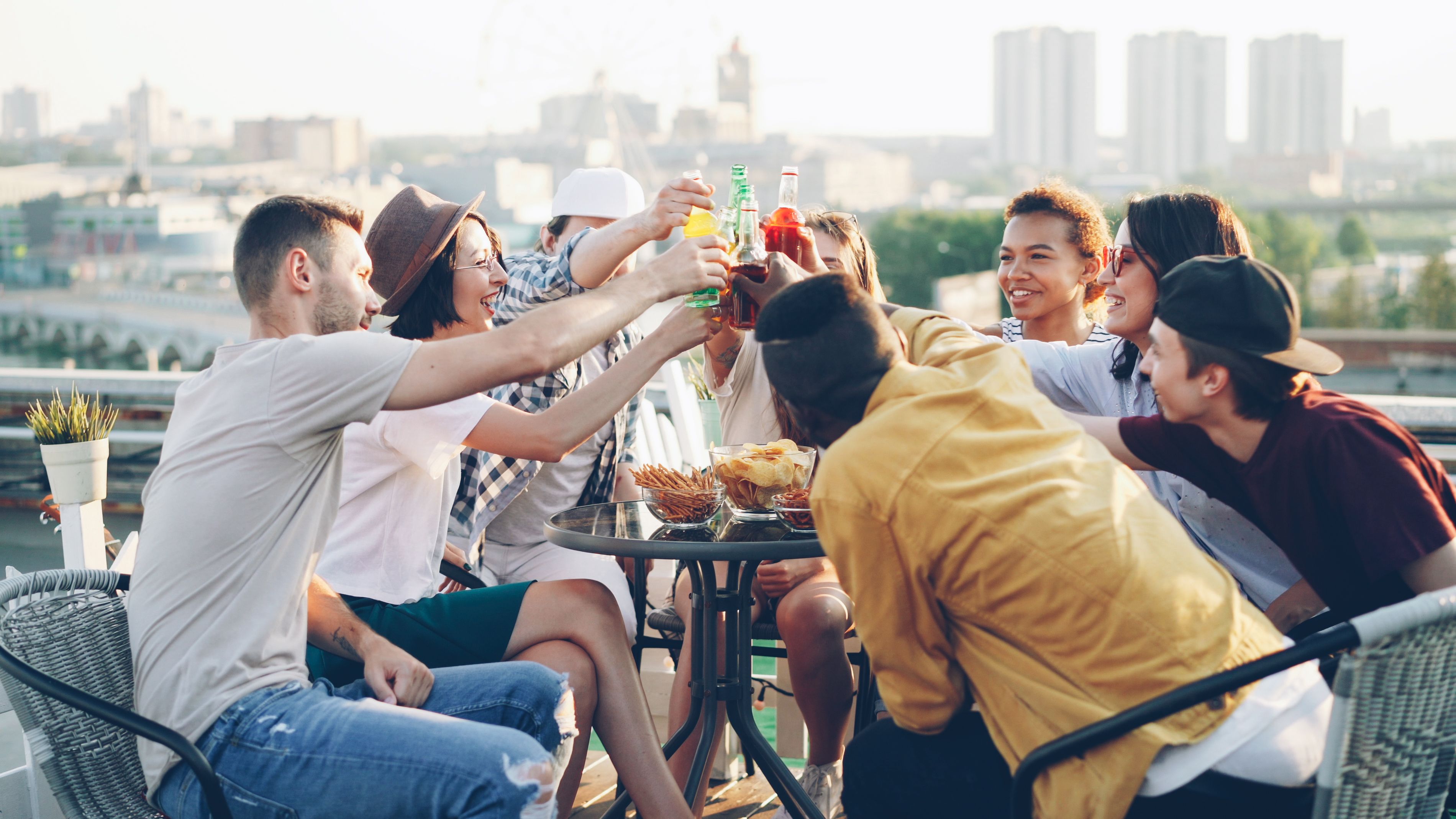 Group of friends enjoying drinks together on a sunny rooftop
