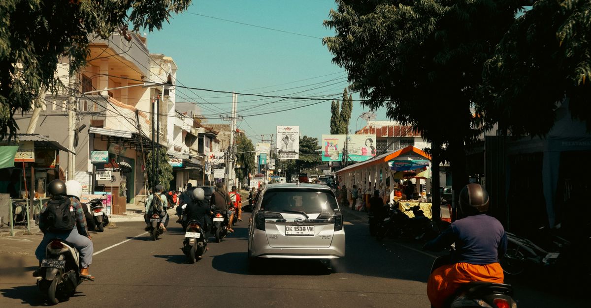 Busy Canggu road in Bali packed with motorbikes and cars at peak hour