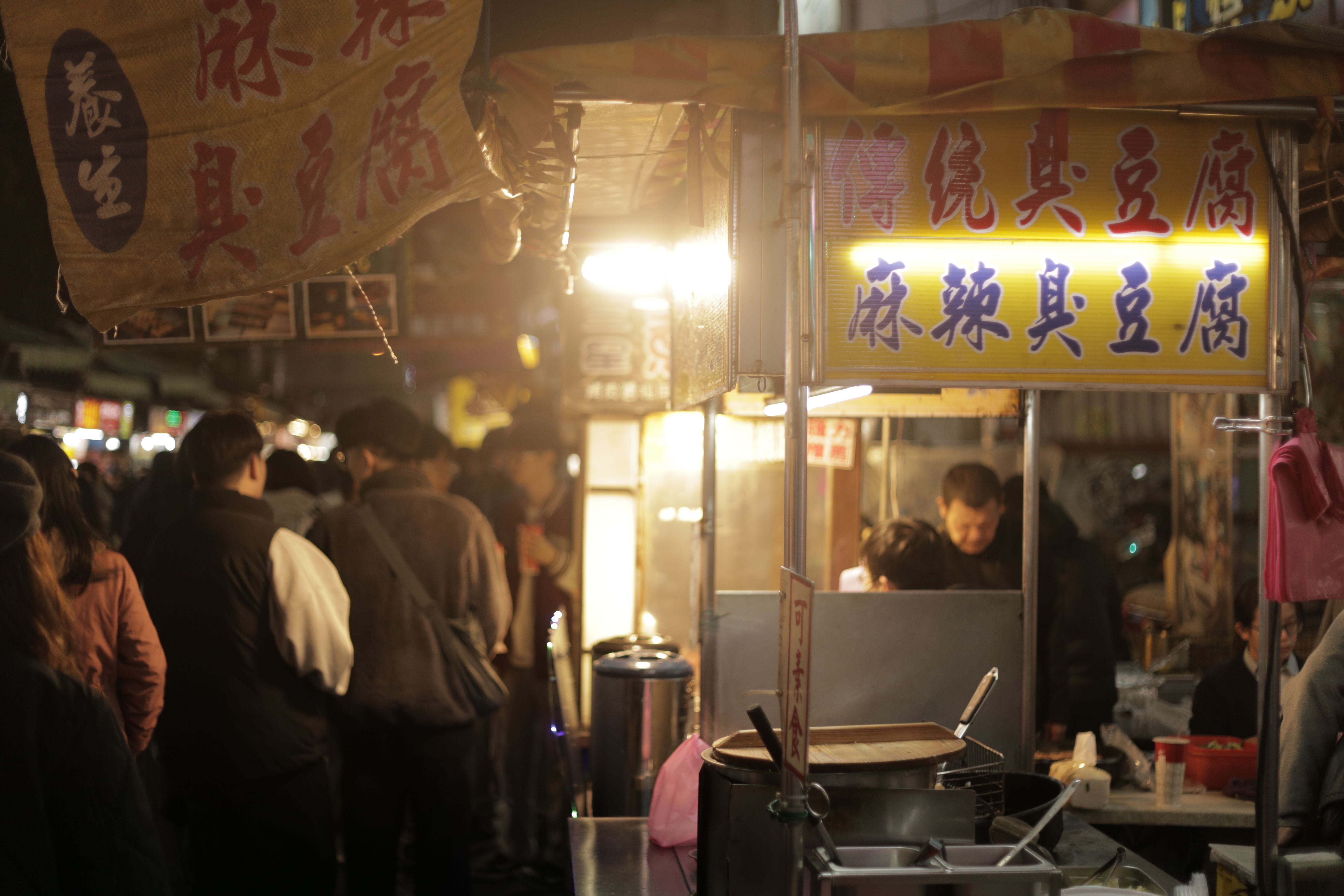 A bustling night market food stall in Asia