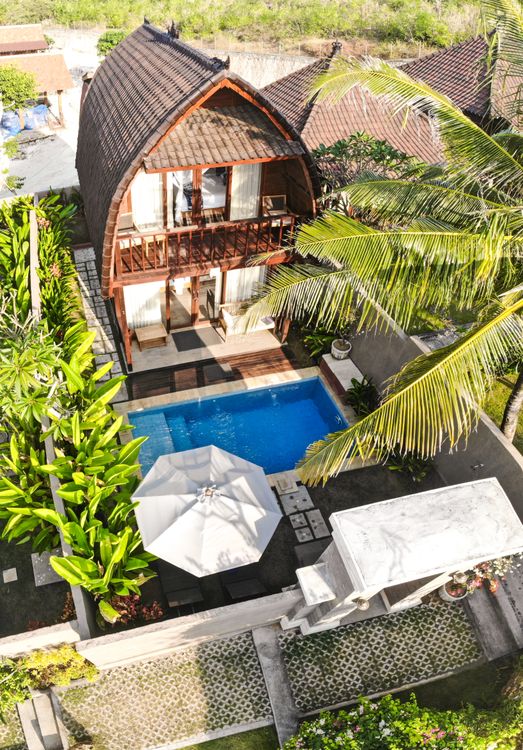 A luxury Bali villa with a swimming pool surrounded by tropical gardens