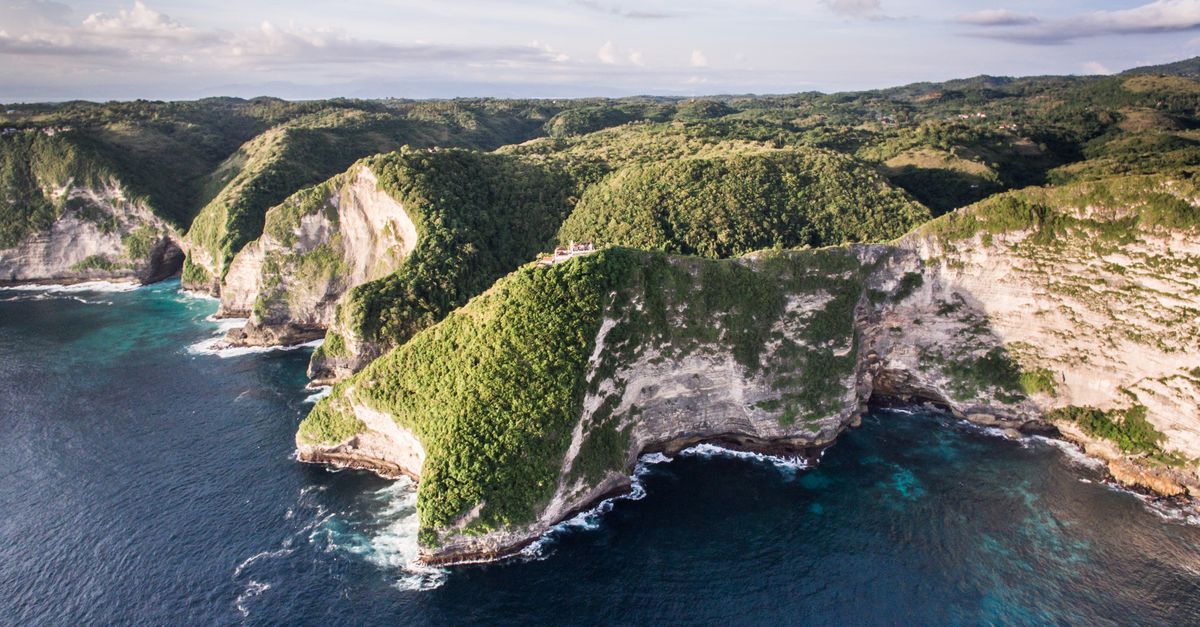 Aerial view of turquoise water and lush green cliffs in the Nusa islands near Bali, Indonesia