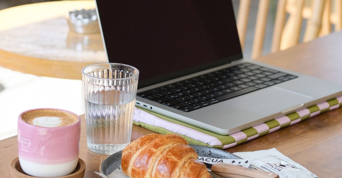 Cosy cafe workspace with laptop and coffee for remote work
