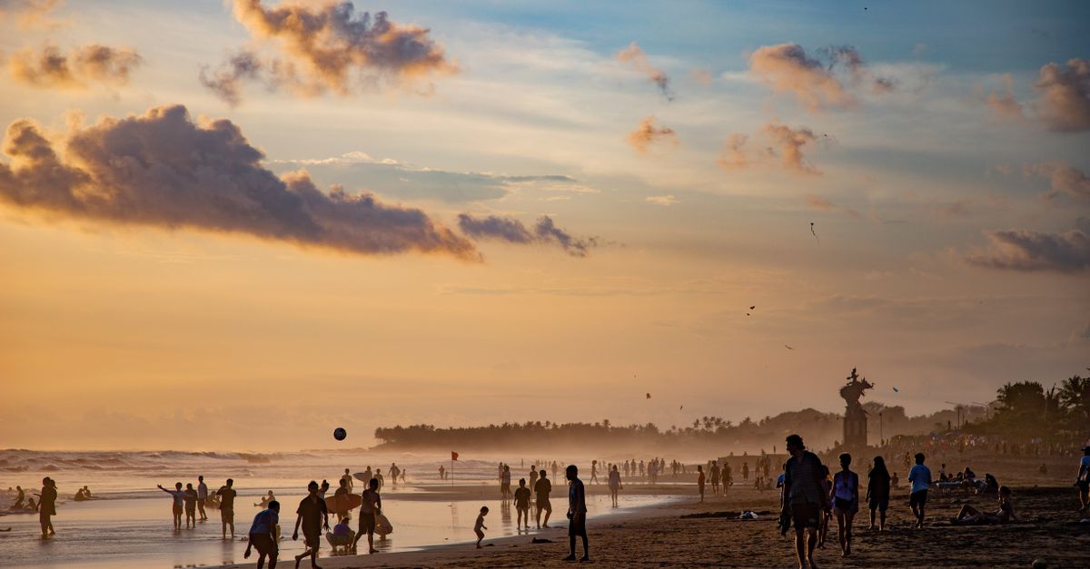 People enjoying a vibrant sunset on the black sand at Canggu Beach, Bali