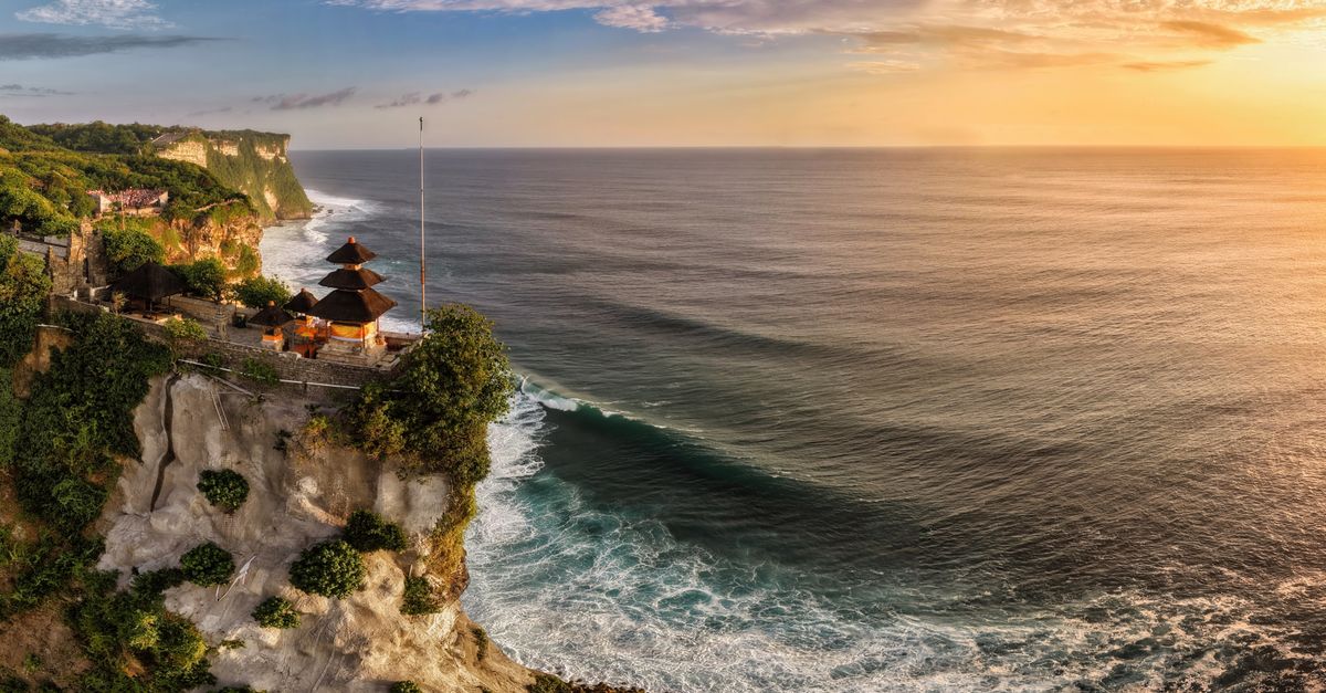 Uluwatu Temple on the clifftops above the ocean at sunset in Bali